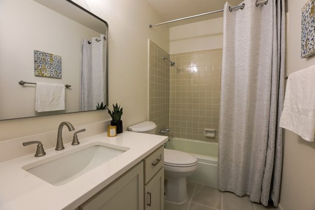 Bathroom featuring custom vanity and shower / bath combination with curtain. | Image 27