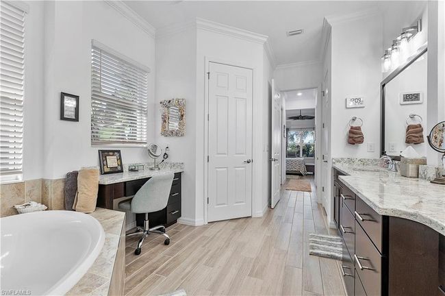 Ensuite bathroom with ornamental molding, wood finished floors, tiled tub, and connected bathroom | Image 49