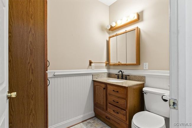 Half bath with a wainscoted wall, toilet, and vanity | Image 35