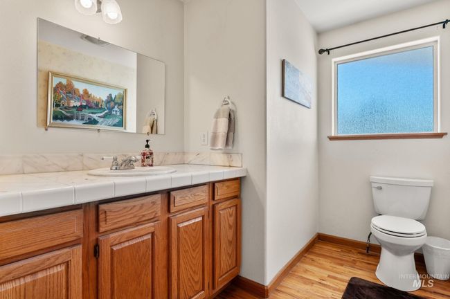 Bathroom with tiled countertop vanity and hardwood finished floors | Image 19