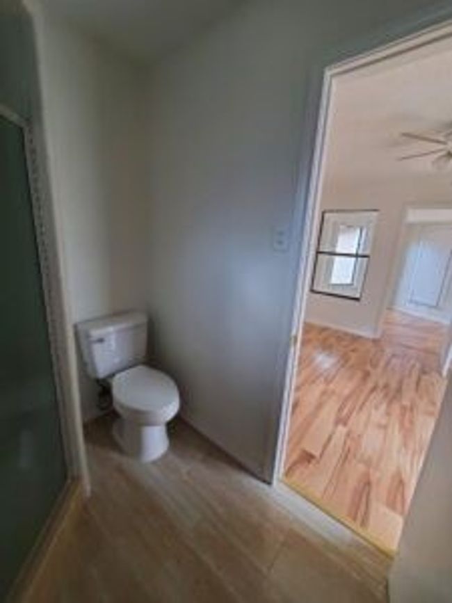 Full bathroom with a shower stall, wood finished floors, and a ceiling fan | Image 39