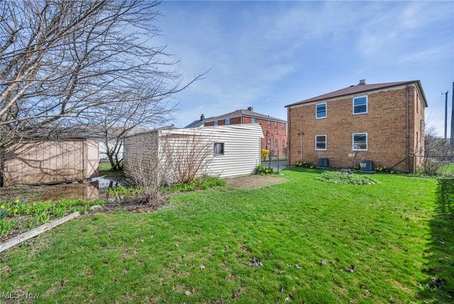 Back of property with a yard, brick siding, an outdoor structure, and central AC unit | Image 5