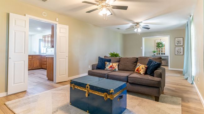 Living area featuring a wealth of natural light, light wood-type flooring, baseboards, and a ceiling fan | Image 10
