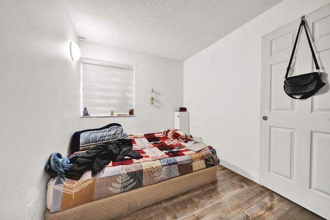 Bedroom with a textured ceiling and wood finished floors | Image 7