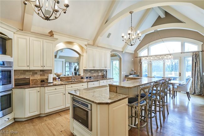 Kitchen featuring, a chandelier, a kitchen island, double oven, and arched beamed ceilings to mirror the arch of the window package! | Image 5