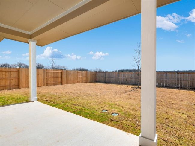 Fenced backyard with a patio | Image 17