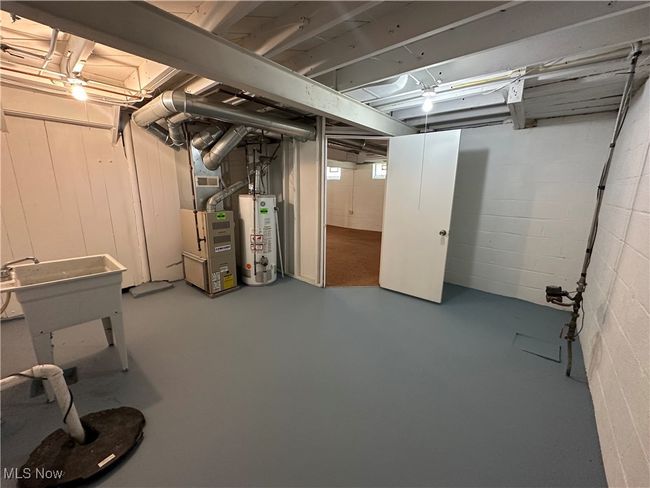 Below grade area featuring water heater and concrete block wall | Image 40