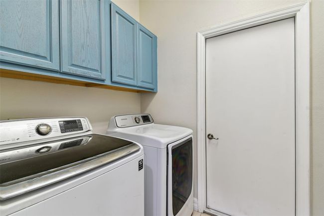 Laundry room includes washer/dryer & cabinets for extra storage. | Image 27