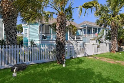 Talk about curb appeal, notice the picturesque picket fence dotting the front yard. Tropical flair is provided by the palm trees which flank the street side. | Image 3