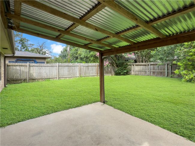 Fenced backyard with a patio | Image 17