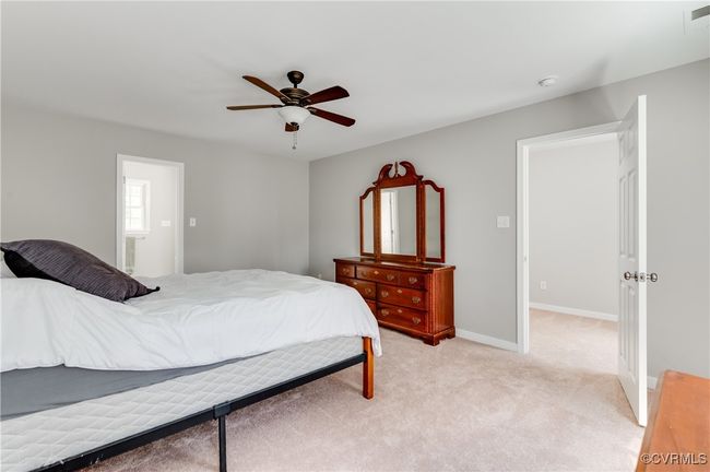 Primary Bedroom with ceiling fan, light colored carpet, and baseboards | Image 16