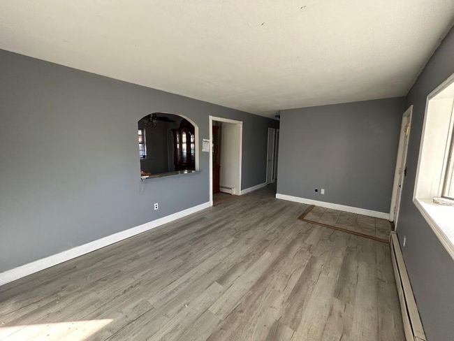 Unfurnished room with a baseboard radiator and light hardwood / wood-style flooring | Image 8