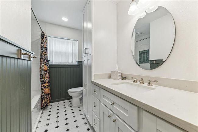 Stunningly remodeled hallway bathroom featuring elegant shiplap, modern cabinets, a sleek countertop and timeless tile flooring. | Image 7