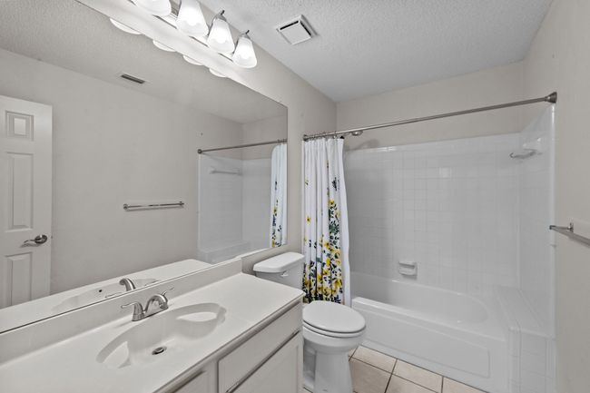 Bathroom featuring tile floors, vanity, shower/ bath combination with curtain, and toilet | Image 30