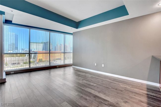 Living room with a raised ceiling, baseboards, wood finished floors, and a wealth of natural light | Image 4