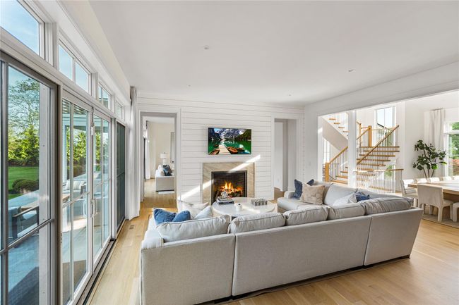 Living room featuring stairway, a high end fireplace, and light wood-type flooring | Image 12
