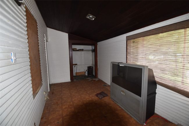 Corridor featuring wood walls, vaulted ceiling, wooden ceiling, and dark flooring | Image 13