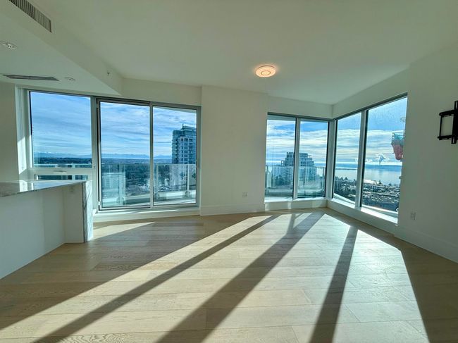 Spare room featuring a city view, a wealth of natural light, visible vents, and wood finished floors | Image 5