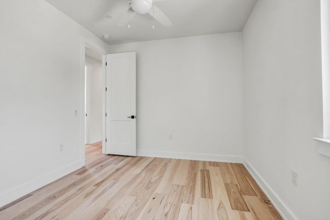 Unfurnished room featuring a ceiling fan, wood finished floors, baseboards, and a smoke detector | Image 25