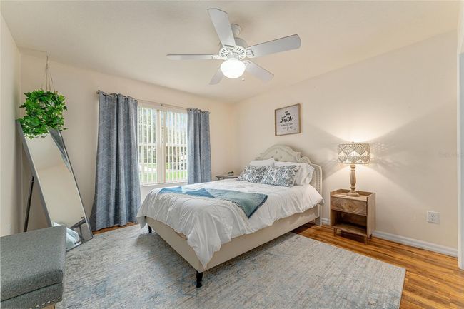 Front guest room has lighted ceiling fan and custom closet. Furniture is optional. | Image 21