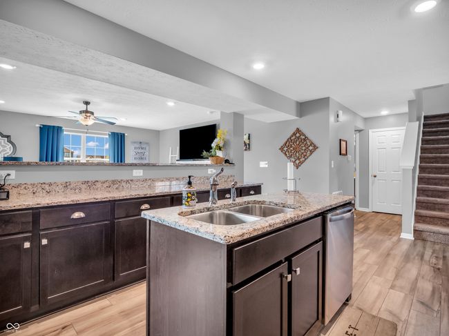 kitchen with recessed lighting, a sink, light wood-style floors, dishwasher, and dark brown cabinets | Image 9