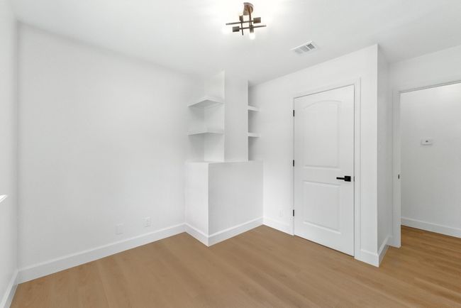 Unfurnished bedroom with light wood-style floors and baseboards | Image 16