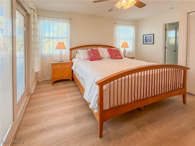 Bedroom with light wood-type flooring, multiple windows, and a ceiling fan | Image 33
