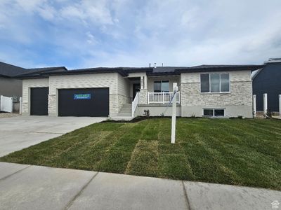 View of front facade with a front lawn and a garage | Image 1