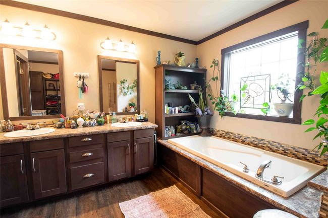 Master Bathroom featuring double vanity, wood finished floors, a garden tub, and crown molding | Image 15