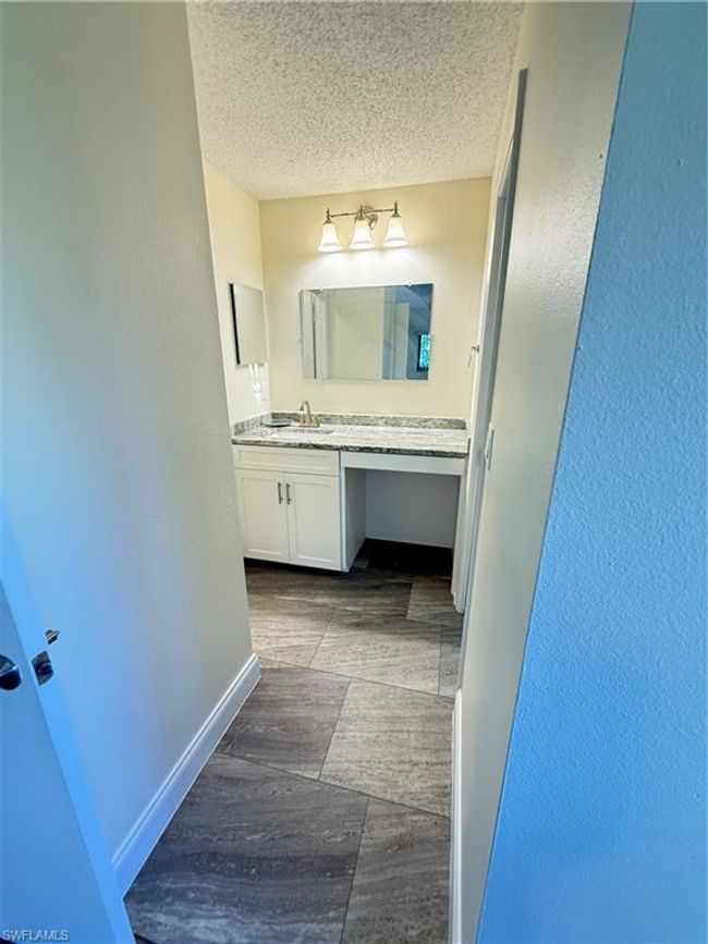 Bathroom with vanity, a textured wall, wood finished floors, and a textured ceiling | Image 14