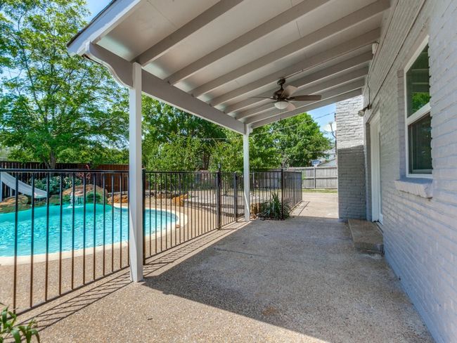 Fenced backyard with a patio area and a ceiling fan | Image 22
