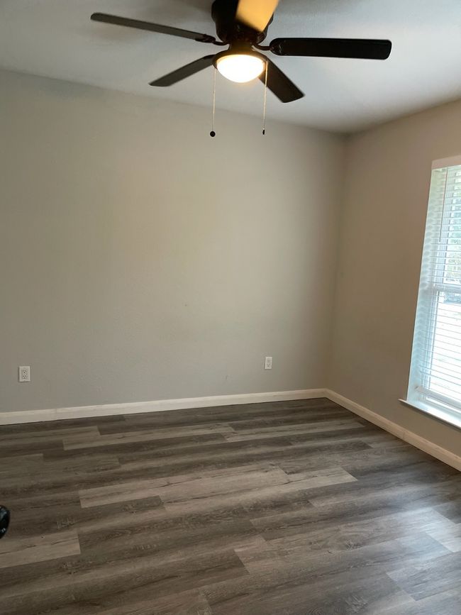 Empty room featuring ceiling fan and dark hardwood / wood-style flooring | Image 4