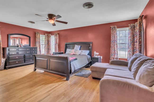 Bedroom featuring light wood-style floors, multiple windows, and ceiling fan | Image 15