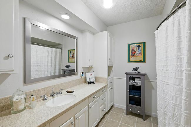 Full bath featuring vanity, a textured ceiling, and tile patterned floors | Image 22