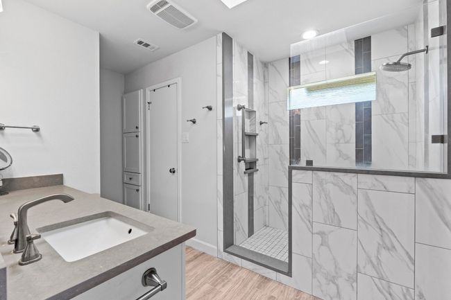 Full bathroom with wood finished floors, visible vents, and a marble finish shower | Image 17