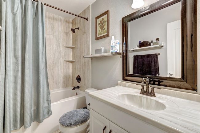 Full bath featuring shower / tub combo, toilet, vanity, and a textured wall | Image 22