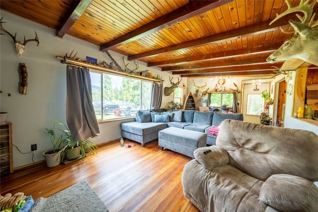 Living area with light wood-style floors and a wood ceiling with exposed beams | Image 30