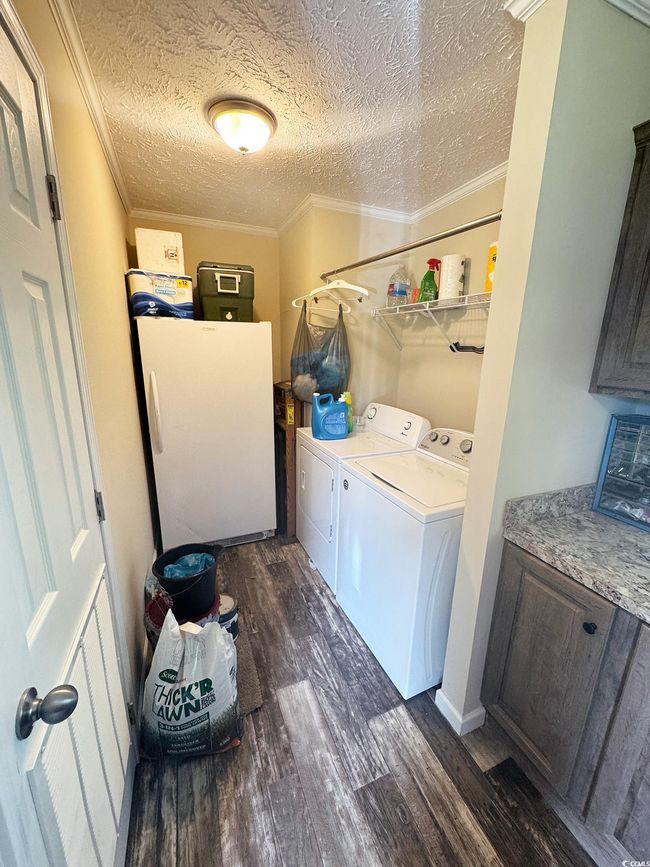Washroom with separate washer and dryer, ornamental molding, a textured ceiling, and dark wood-type flooring | Image 32