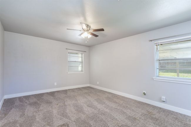 Unfurnished room with baseboards, carpet flooring, and ceiling fan | Image 18