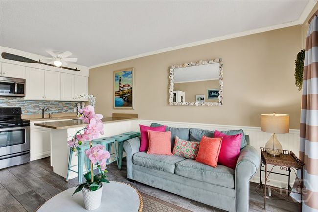 Open Living Area with Sleeper Sofa & Plenty of Natural Light Plus Access to Private Outdoor Balcony with Sunset & Partial Water Views! | Image 7