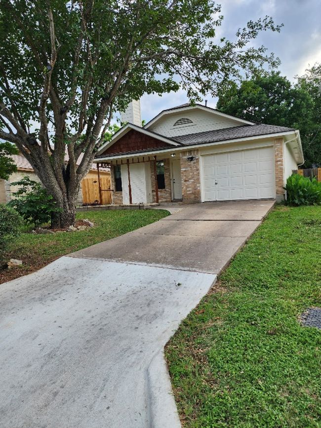 View of front facade with concrete driveway, an attached garage, and brick siding | Image 8