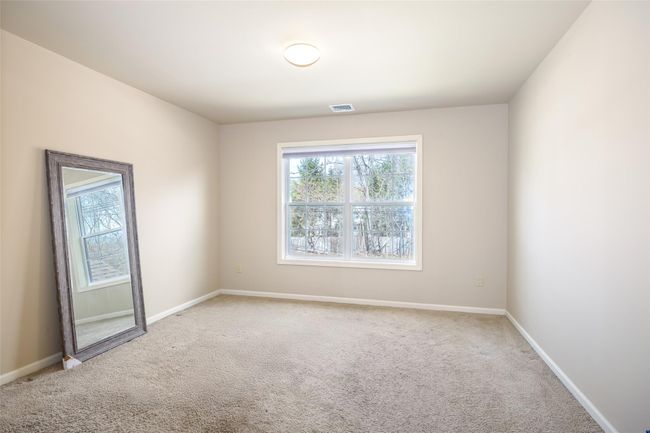 Carpeted empty room featuring visible vents and baseboards | Image 18