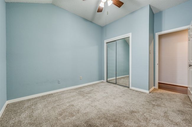 Unfurnished bedroom with carpet, a closet, vaulted ceiling, ceiling fan, and a textured ceiling | Image 15