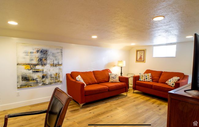 Living area with light wood-type flooring, recessed lighting, baseboards, and a textured ceiling | Image 16