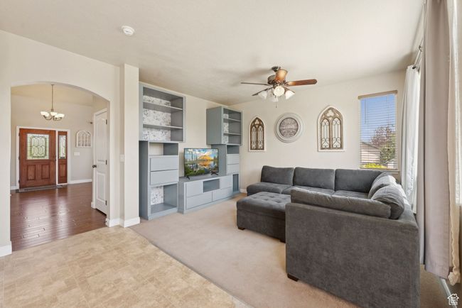 Living room with arched walkways, ceiling fan, and a chandelier | Image 10