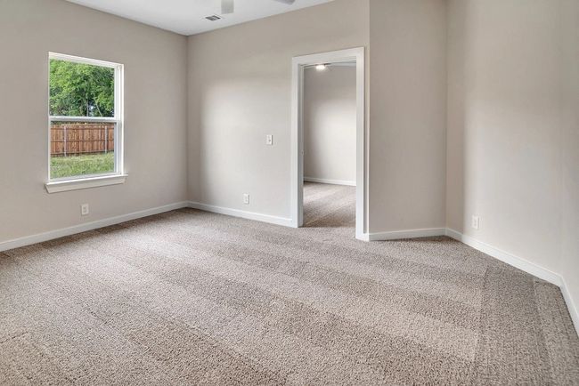 Carpeted empty room with baseboards and a ceiling fan | Image 22