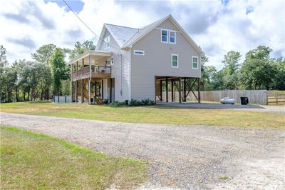 View of front of house with a balcony, a front yard, and a carport | Image 1