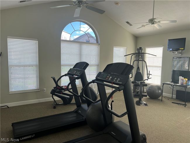 Clubhouse Exercise room with vaulted ceiling, carpet floors, and ceiling fan | Image 39