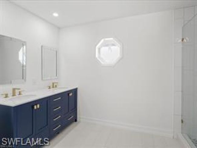 Bathroom with dual vanity, a shower, and tile flooring | Image 14