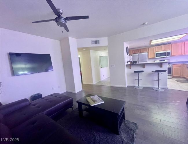 Living area with visible vents, baseboards, light wood-type flooring, and a ceiling fan | Image 20